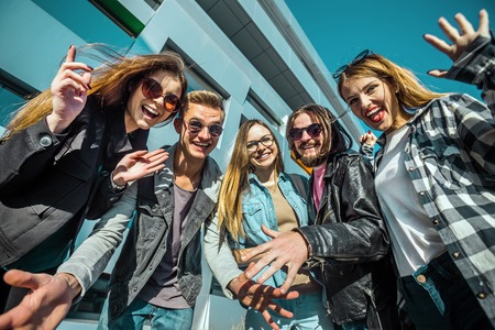 Casual stylish group of happy smiling students before modern buildingの写真素材