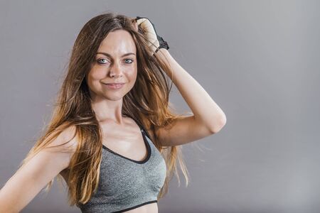 Pretty dark hair sportswoman wearing a grey top in the grey isolated backgroundの写真素材