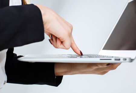 Young cheerful smiling businesswoman holds laptop in hands on white isolated background with copyspaceの写真素材