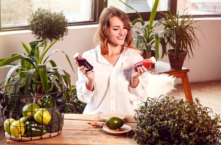 Smiling girl having delicious smooze, indoor shot among green plantsの写真素材