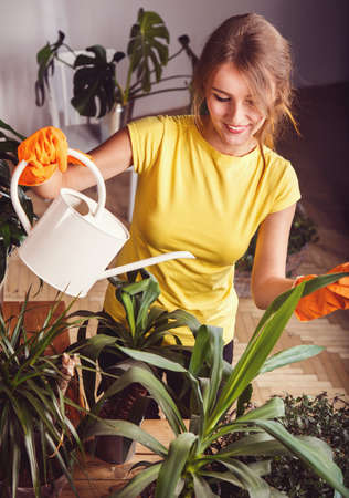 Cheerful girl taking care of green plantsの写真素材