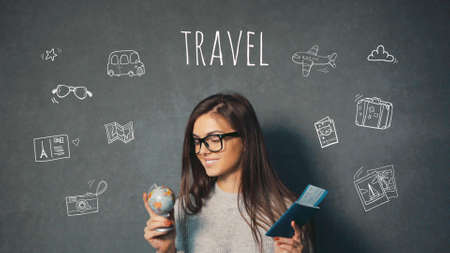 Beautiful long-haired girl taking a view of countries on the globe happily, isolated shotの写真素材
