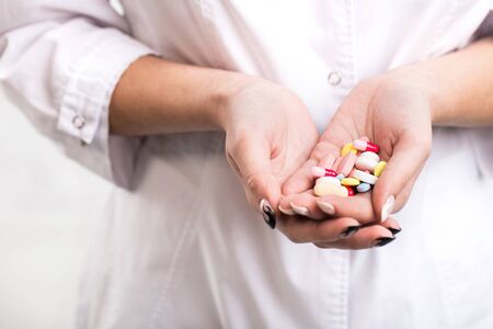 Closeup of a woman doctor holding colorful pills in his hands