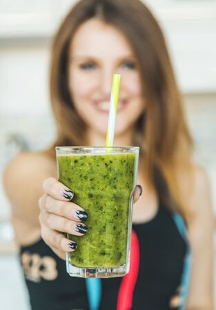 Woman holding glass of green fresh smoothieの写真素材