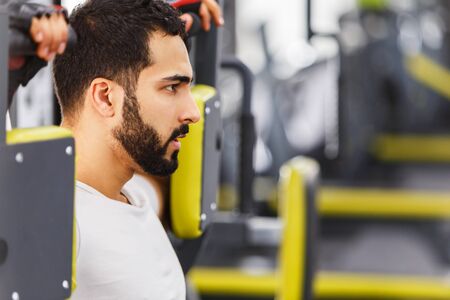 Bearded man wears white t-shirt have rest while sitting in the gym