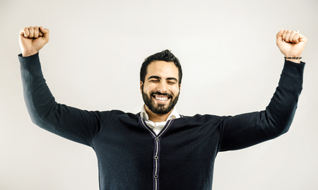 Bearded smiling man holds hands rise up on isolated white background, winner conceptの写真素材
