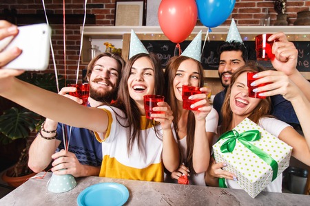 Best friends making selfie and selebrating birthday together at the party on the kitchen