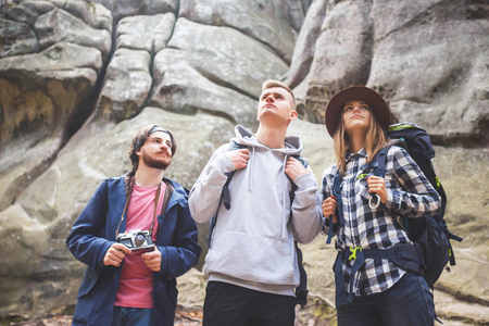 Portrait of adventure students with backpacks walking on the rocks and searching the route, travelling conceptの写真素材
