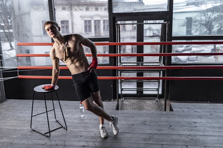 Muscular athlete man with rope near chair in the ring