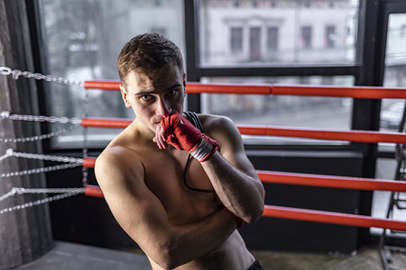 Muscular athlete boxer man with rope in the ringの写真素材
