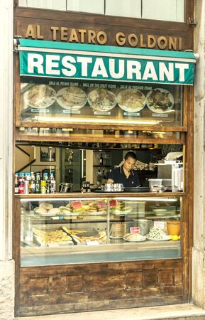 VENICE, ITALY - 25 August, 2018: Fast food restaurant showcase with a waiter who prepares food insideのeditorial素材