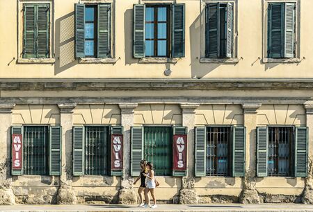 VERONA, ITALY - AUGUST 26, 2018: Symmetrical view on a fasad of house in Verona, people walking on the streetのeditorial素材