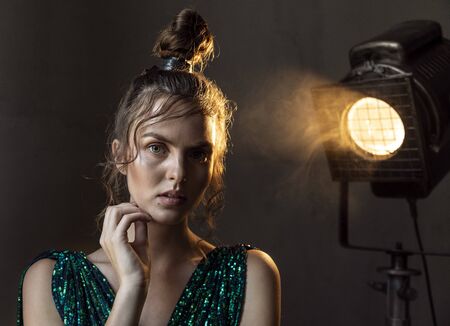 Charming woman with a beauty spot looking at you with face half-shadowed