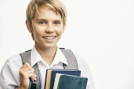 Smiling blond boy carrying books and a schoolbagの写真素材