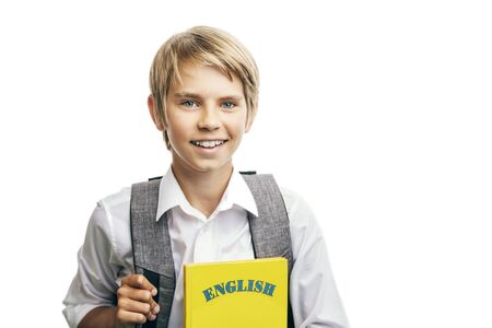 Smiling boy with a rucksack holding english textbook