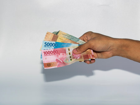 Hand holding indonesia banknote of 1000 baht on white backgroundのeditorial素材