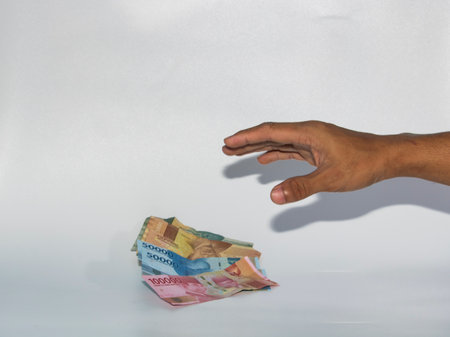 Hands reaching for money, isolated on a white background, studio shotのeditorial素材