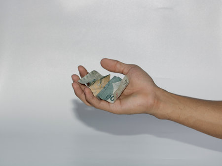 Hand holding money isolated on white background, business and finance concept.のeditorial素材