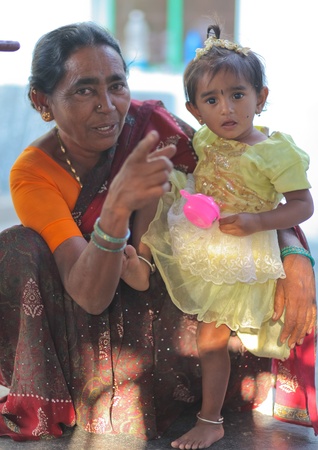 HAMPI â JANUARY 15 : Grandmother caring for grandchild in Hampi, India on January 15, 2011. In India Itのeditorial素材