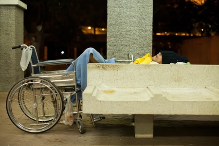 BANGKOK Ð JANUARY 13 : Homeless disabled man sleeping on a public concrete bench under brigde in downtown Bangkok on January 13, 2012. Downtown was spared of flooding in recent  disastrous floods in Thailand.のeditorial素材
