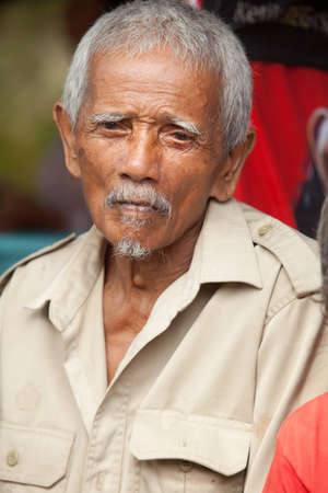BALI - JANUARY 20. Old man assisting Cock fighting contest in Bali on January 20, 2012 in Bali, Indonesia. Cock fights are illegal, however are tolerated out of traditional.のeditorial素材