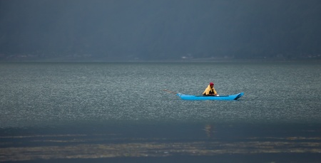 LAKE BATUR, BALI - JANUARY 21. Man fishing in boat on Lake Batur on January 21, 2012 in Bali, Indonesia. Fish is part of the stape diet on the lake.のeditorial素材