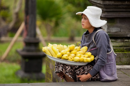BALI - JANUARY 22. Balinese woman selling maize to pilgrims at Mother Temple in Besakih on January 22, 2012 in Bali, Indonesia. It is common to buy refreshments and food from street vendors in Besakihのeditorial素材