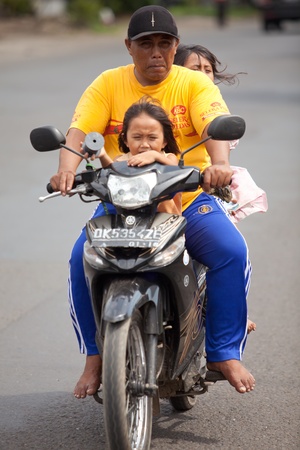 BALI - JANUARY 26. Father and daughters driving to town by bike on January 26, 2012 in Bali, Indonesia. Most Balinese people cannot afford cars and drive with motorcycles.のeditorial素材