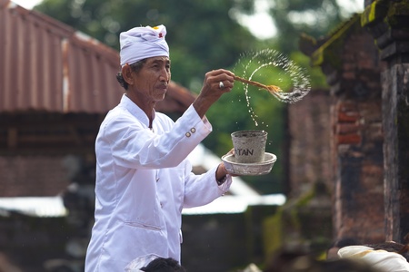 BALI - FEBRUARY 1. Priest blessing worshippers with holy water for Galungan ceremony on February 1, 2012 in Bali, Indonesia. Galungan's a Balinese holiday occuring every 210 days lasting 10 days.のeditorial素材