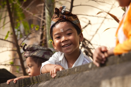 BALI - FEBRUARY 1. Local kids play on temple wall during Galungan festivities on February 1, 2012 in Bali, Indonesia. Galungan's a Balinese holiday occuring every 210 days lasting 10 days.のeditorial素材