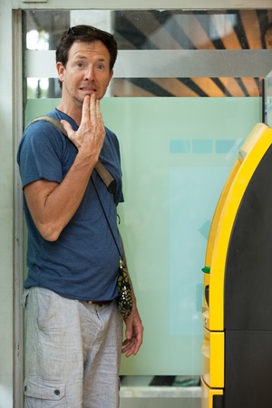Young caucasian man withdrawing money at ATMの写真素材