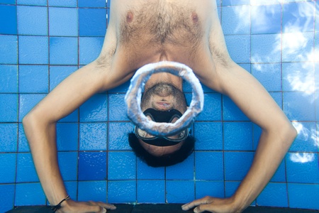 Man making bubble rings underwater in poolの写真素材