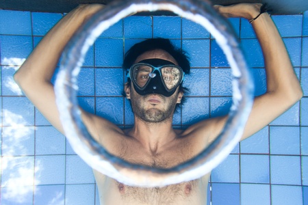 Man making bubble rings underwater in poolの写真素材