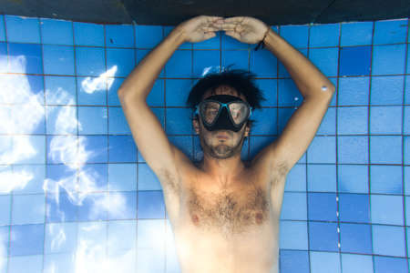 Man making bubble rings underwater in poolの写真素材