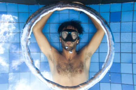 Man making bubble rings underwater in poolの写真素材
