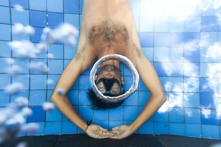 Man making bubble rings underwater in poolの写真素材