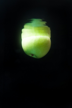 Green apple floating in water on black backgroundの写真素材