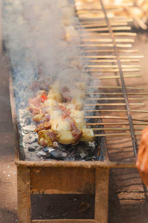Small barbecue grilling satay skewers on coalの写真素材