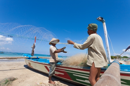 BALI - FEBRUARY 13. Fishermen cleaning nets on beach on February 13, 2012 in Bali, Indonesia. Fisheries Minister Fadel Muhammad said Indonesia set to become world's largest fish producer in 2015.のeditorial素材