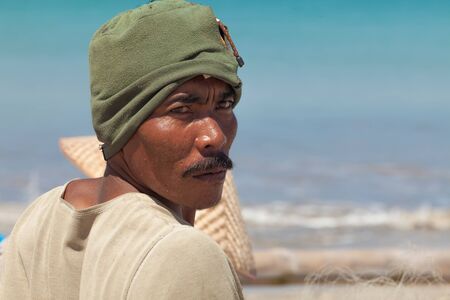 BALI - FEBRUARY 13. Fishermen cleaning nets on beach on February 13, 2012 in Bali, Indonesia....