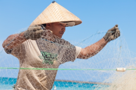 BALI - FEBRUARY 13. Fishermen cleaning nets on beach on February 13, 2012 in Bali, Indonesia. Fisheries Minister Fadel Muhammad said Indonesia set to become world's largest fish producer in 2015.のeditorial素材