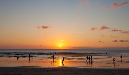 People enjoying sunset on Kuta beach in Bali, Indonesiaの写真素材