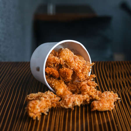Chicken poppers with white cup laid on a wooden tableの写真素材