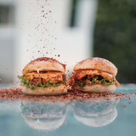Chicken Zinger Burger with sesame beans topping and filled with vegetables with crushed red chiliの写真素材