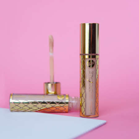 Liquid lipstick, Lip gloss in elegant glass bottle with white lid. Trendy colors of the season with white backgroundのeditorial素材