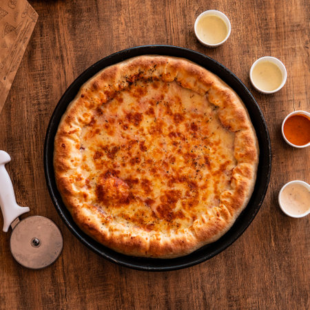 Pizza with mozzarella cheese and tomato sauce on wooden tableの写真素材