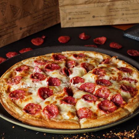 Pizza with salami and mozzarella on a black backgroundの写真素材