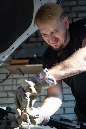 The mechanic repairs the car under the hoodの写真素材