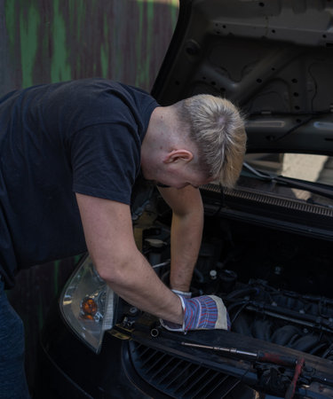 The mechanic repairs the car under the hoodの写真素材