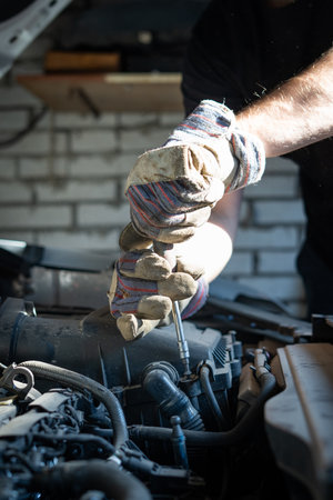 The mechanic repairs the car under the hoodの写真素材